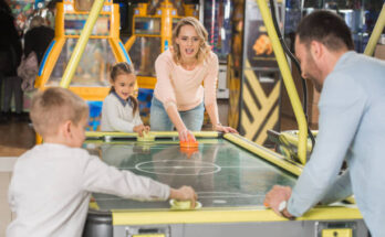 family playing air hockey together in entertainment center