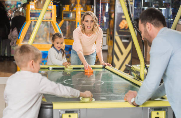 family playing air hockey together in entertainment center